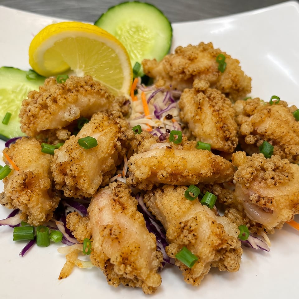 Golden fried calamari with scallions, cabbage slaw, cucumber, and lemon.