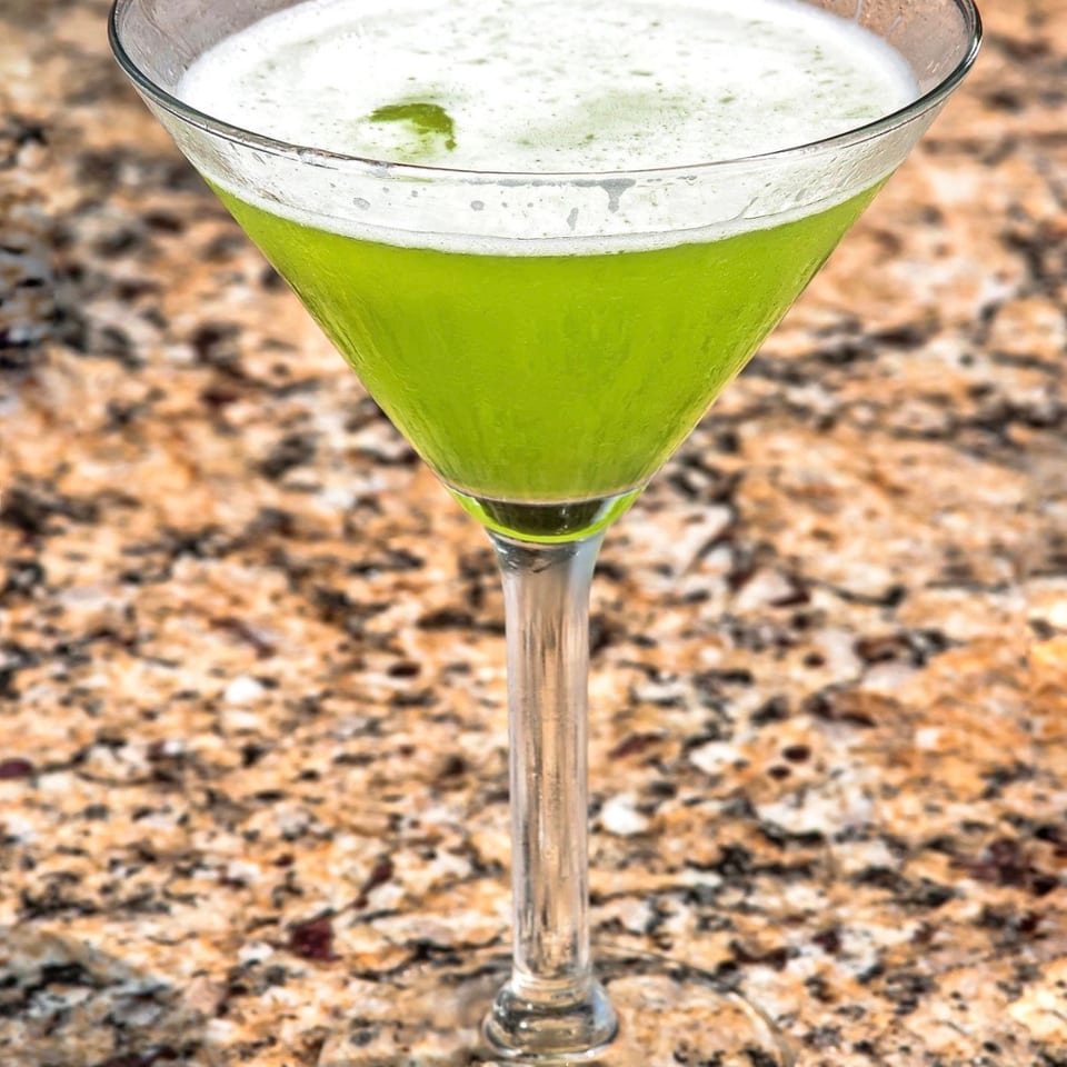 Bright green martini cocktail in a chilled glass.